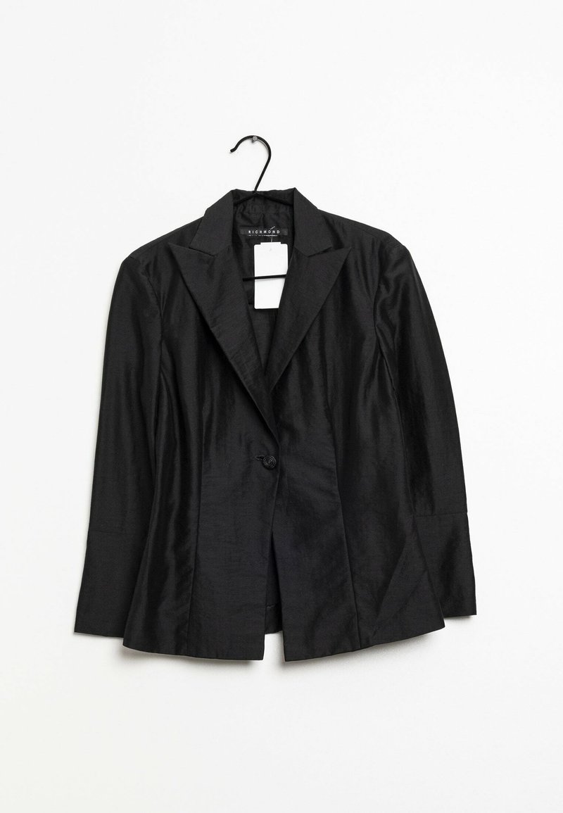 Svart blazer i slät tyg med spetsig krage, enkel knäppning och långa ärmar. Hänger på en svart krok.