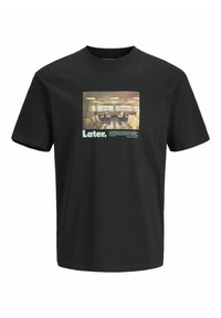 Sort bomulds T-shirt med en rektangulær grafik af et rum med stole, teksten "Later." i hvid, og detaljerede billedtekster under billedet.