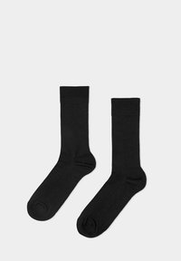 Schwarze Baumwollsocken mit geripptem Design, in mittlerer Wadenlänge, glatter Textur und verstärkten Zehenbereichen. Keine sichtbaren Muster oder Akzente.