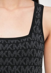 Čierny pletený tielkový top s textúrovaným vzorom prepletených písmen, so štvorcovým výstrihom a tenkými ramienkami.