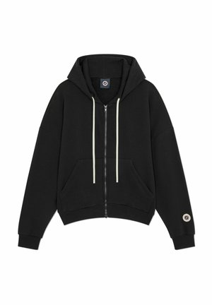 Sudadera negra con cremallera, bolsillos delanteros, cordones blancos, puños acanalados y un parche circular con logo en la manga izquierda.