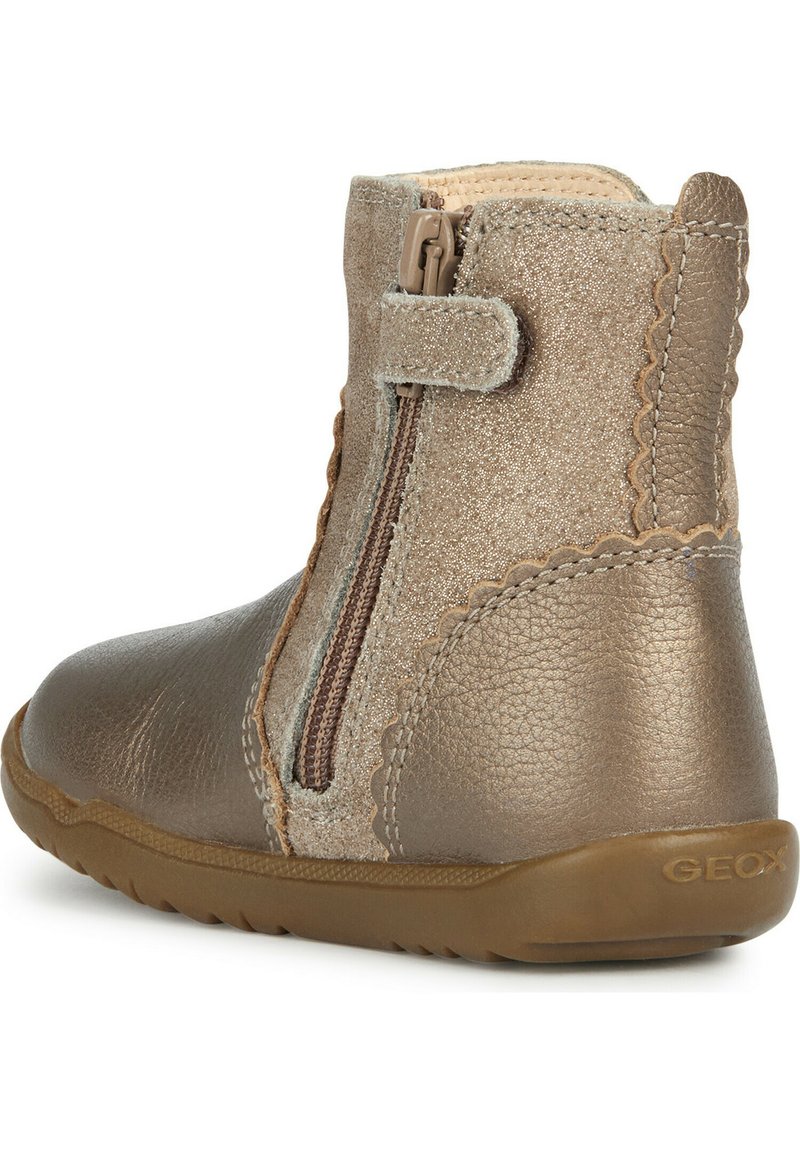 Braune Knöchelstiefel mit einer strukturierten Lederoberfläche, seitlichem Reißverschluss und gewellten Akzenten. Mit einer Gummisohle, geeignet für Freizeitkleidung.