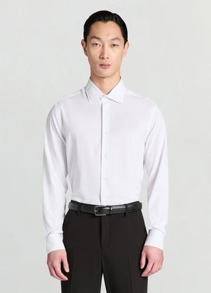 White long-sleeve button-up shirt with a spread collar, tailored fit, and smooth texture, worn with black dress pants and a matching belt.