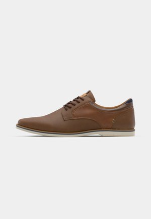 Scarpa di pelle marrone con una texture liscia, punta arrotondata, suola bianca in contrasto e sottili dettagli di cucitura. Design classico con lacci.