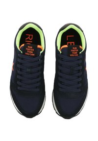 Ein Paar navyblaue Laufschuhe mit neongrüner Innenausstattung, orangefarbenen Akzenten und dem Text "LAUF SCHNELLER ALS DU KANNST" auf den Zungenlaschen.