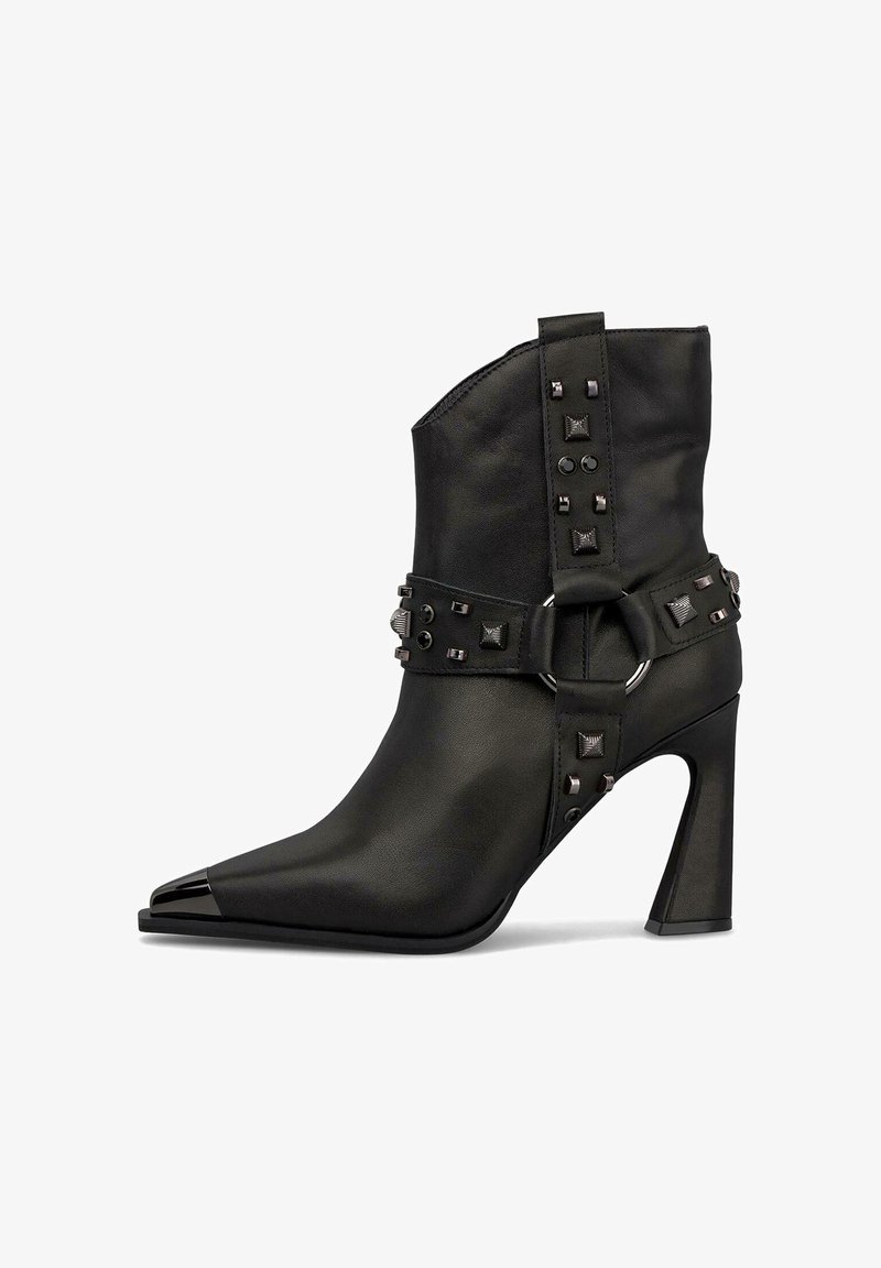 Czarne skórzane botki za kostkę z ostro zakończonym noskiem, metalowymi ćwiekami i dekoracyjnym paskiem z okrągłą klamrą. Projekt obcasa typu szpilka.