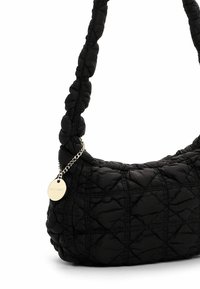 Sac à épaule noir matelassé avec un tissu texturé, accent en chaîne et une étiquette logo ronde. Présente une forme douce et arrondie ainsi qu'un design rebondi.