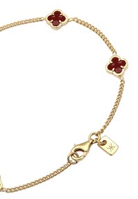 Goldene Armbandkette mit roten, blumenförmigen Akzenten, einem Karabinerverschluss und einem gravierten rechteckigen Anhänger.