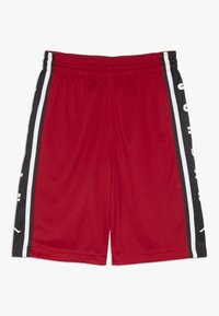 Pantalones cortos deportivos rojos con rayas laterales en blanco y negro y cintura elástica, que presentan texto blanco parcial en las rayas negras.