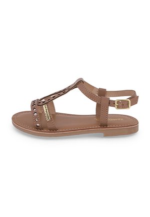 Sandalia de cuero marrón con detalles recortados, correa ajustable en el tobillo, suela plana y detalle dorado en el lateral. Textura suave, diseño sencillo.