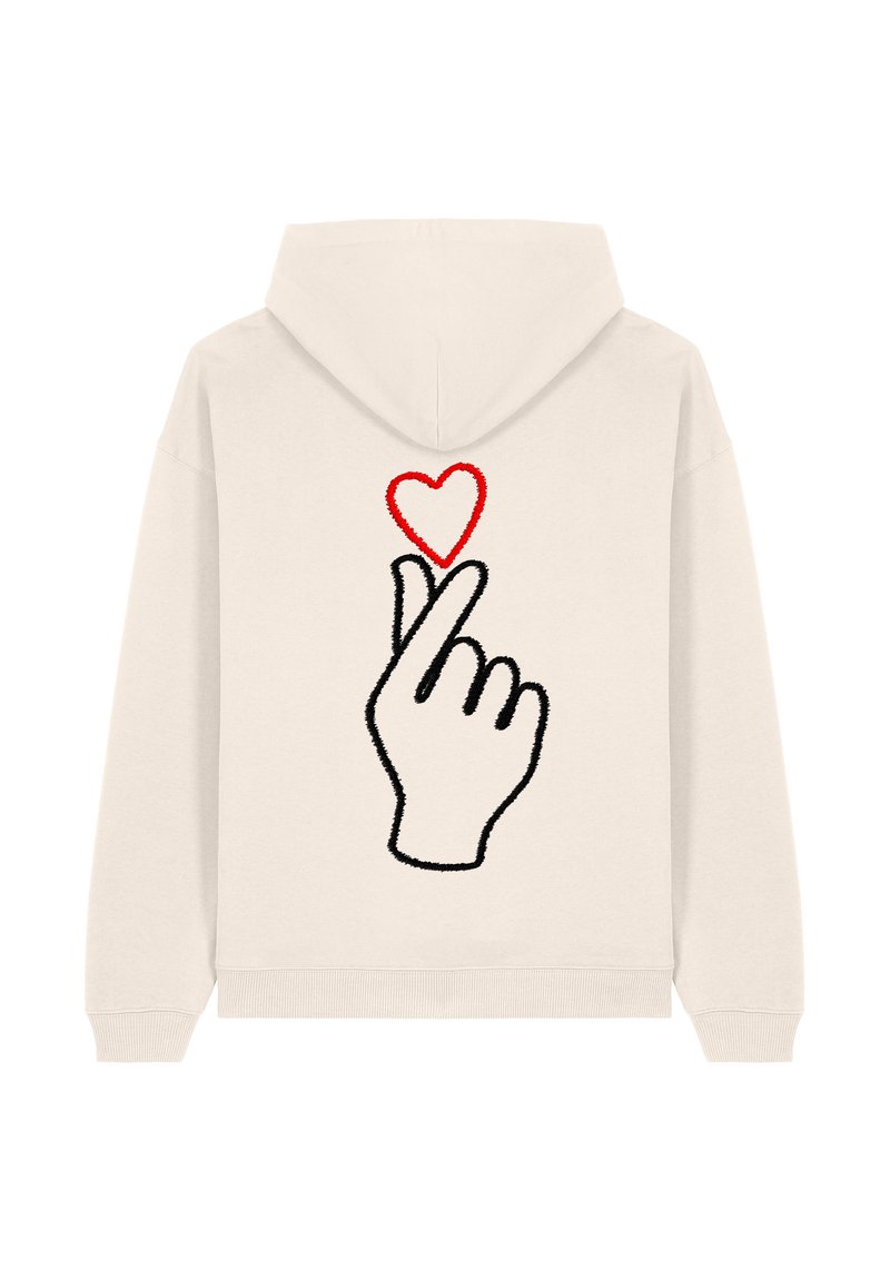 Sudadera crema con un diseño bordado de una mano haciendo un gesto de corazón, con un corazón rojo arriba. Tejido suave, corte holgado.