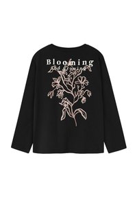 Schwarzes Langarmshirt mit einer hellrosa floralen Illustration und den Worten "Aufblühen und Wachsen" auf dem Rücken gedruckt.