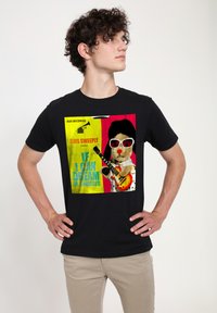 Sort t-shirt med et farverigt grafisk design af en bjørn med solbriller, der holder en guitar, og tekst der refererer til "Elvis Sweeply."