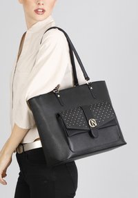 Borsa a tracolla nera realizzata in materiale testurizzato, con una parte anteriore a patta accentata in oro, design borchiato e due tracolle.