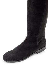 Stivale alto fino al ginocchio in camoscio nero con punta arrotondata, texture liscia e suola piatta in gomma. Cuciture decorative lungo la gamba.