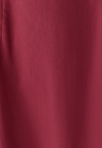 Tissu en lin rouge avec une texture lisse, présentant un léger éclat. La couleur est uniforme, sans motifs ni accents visibles.