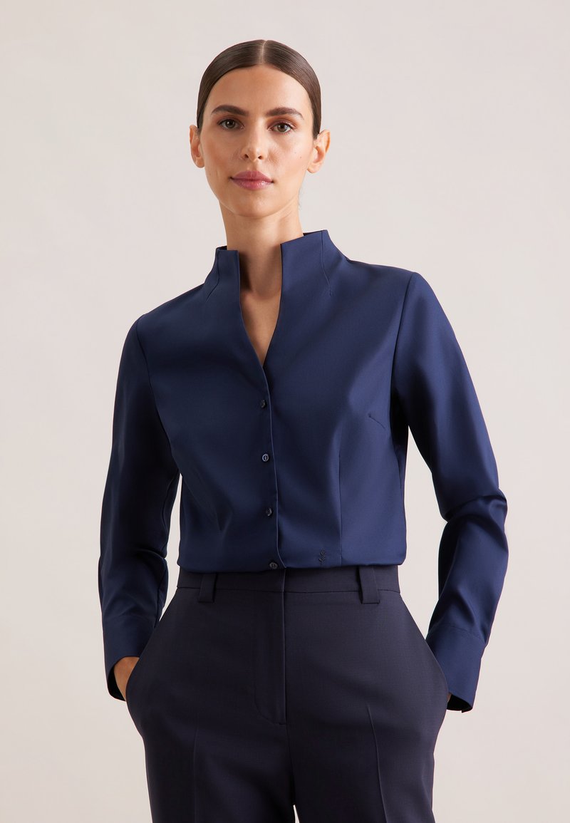 Navy blue button-up shirt with a high collar, long sleeves, and a fitted design; smooth texture and minimalistic detailing.