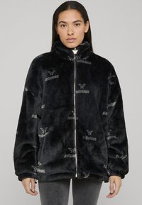 Fleecejakke med glidelås i svart med preget "Delicious"-mønster. Har høy krage og avslappet passform med vide ermer.