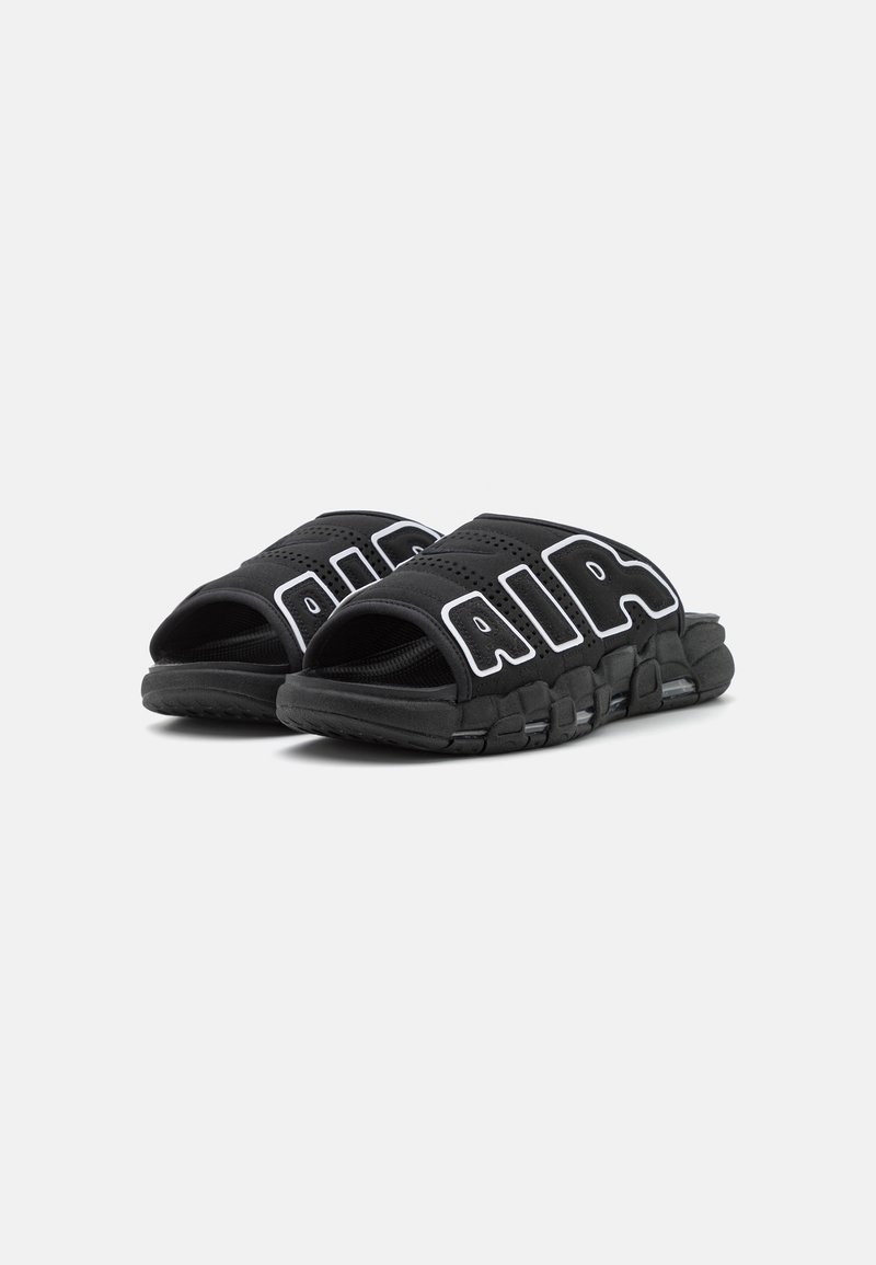 Chanclas negras con diseño de punta abierta, que presentan un gran texto "AIR" en blanco, textura perforada y una suela texturizada para mayor agarre.