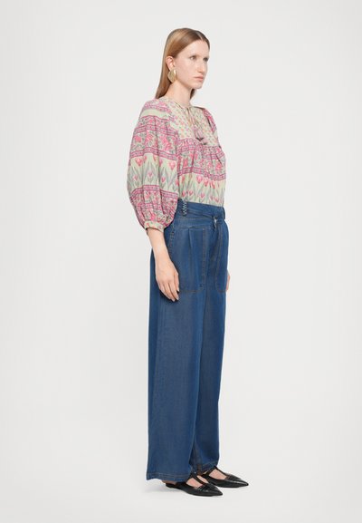 Floral-patterned blouse with puff sleeves, paired with high-waisted wide-leg blue denim trousers. Black pointed flats complete the look.