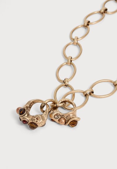 Collier chaîne épaisse en or avec de grands maillons ovales et deux pendentifs en or irréguliers ornés de petites pierres précieuses marron et rouges.