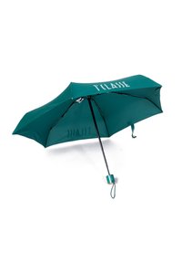 Ombrello color teal con forma arrotondata, struttura in metallo nero e testo bianco. Superficie in tessuto liscia, caratterizzata da un design compatto e un cinturino da polso.