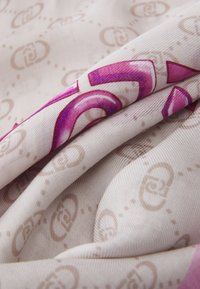 Tessuto setoso con uno sfondo beige chiaro; presenta bold motivi curvi rosa e sottili loghi marroni sparsi. Finitura testurizzata.