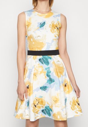 Robe florale avec des motifs jaunes et bleus, sans manches, col rond et une ceinture noire à la taille. Jupe évasée avec une texture lisse.
