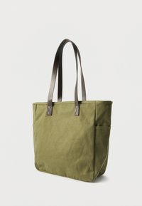 Πράσινη τσάντα χειρός από καμβά με μακριές, ταουπέ λαβές, διαθέτει δύο πλαϊνές τσέπες και απλό, δομημένο σχέδιο. Υφή υφάσματος με ανάγλυφη επιφάνεια.