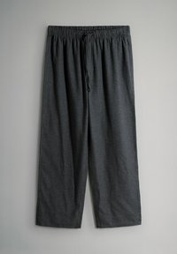 Luźne spodnie w czarno-szare kratę z elastycznym pasem i sznurkiem, prezentowane na jednolitym jasnym tle.