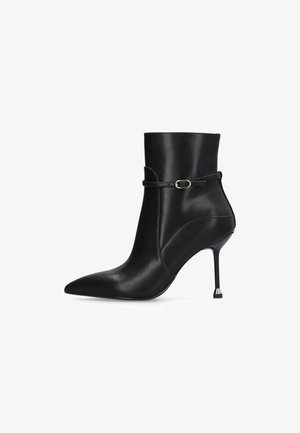 Zwarte enkellaarsjes van glanzend leer met een spitse neus, dunne stilettohak en een decoratieve band met een metalen gesp detail.
