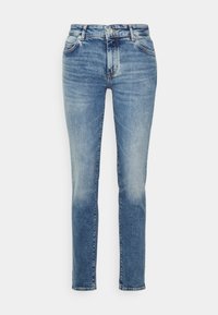 Jeans de tiro alto y pierna recta en denim azul claro. Presenta un leve desgaste, cinco bolsillos y cierre de botón metálico. Detalle de costura distintiva.