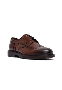 Brązowe skórzane buty brogue z perforowanymi detalami, z zapięciem na sznurówki i niskim, warstwowym obcasem na białym tle.