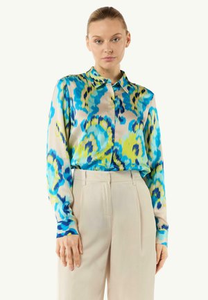 Langarm shirt in een levendig blauw en groen abstract patroon, gemaakt van een soepele stof, heeft een kraag en een knoopsluiting aan de voorkant.