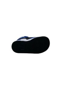 Semelle de chaussure en caoutchouc noir texturé, avec une partie supérieure blanche, des accents bleus et un motif de semelle.
