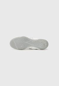 Shoe outsole featuring a textured gray rubber material with circular and hexagonal patterns, and subtle branding details near the heel.