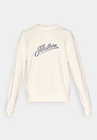 Krémová mikina so šedý kurzívou napísaným logom "Malbon", s okrúhlym výstrihom, rebrovanými manžetami a spodným lemom, s viditeľnými švovými detailmi.