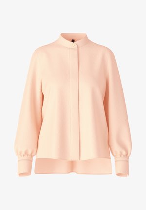 Blouse rose clair à manches longues avec col montant, boutons dissimulés sur le devant, manches bouffantes et poignets boutonnés.