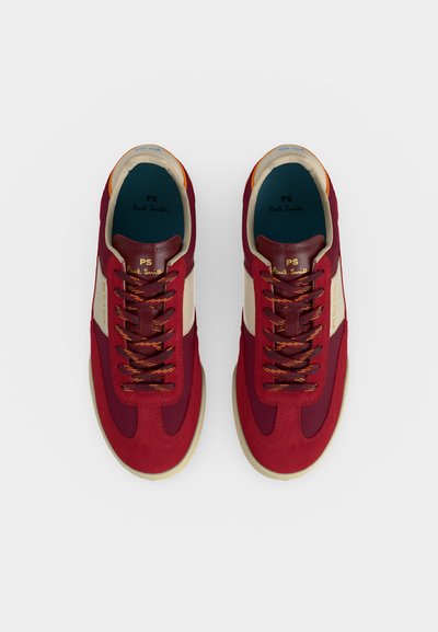 Ζευγάρι κόκκινα και εκρού sneakers με κορδόνια, μπεζ σόλες και σήμανση "PS Paul Smith" στο εσωτερικό και στη γλώσσα, από ψηλά.