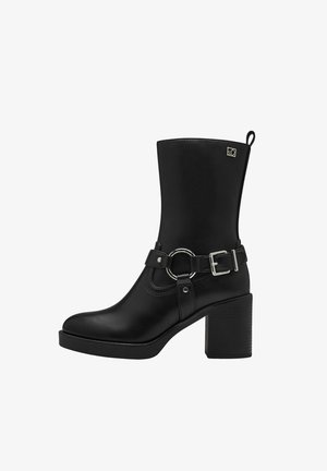 Stivale alla caviglia in pelle nera con punta rotonda, alto tacco a blocco, cinturino regolabile con fibbia e un accento circolare, e un'asola laterale per una facile indossabilità.