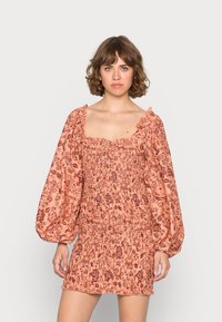 Vestido com padrão floral em tecido pêssego suave, possui mangas bufantes, corpo franzido e decote com babados, com comprimento de mini ajustado.