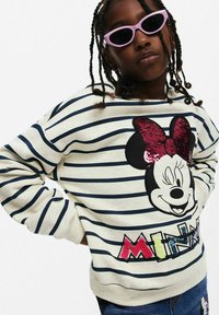 Felpa a righe in crema e blu navy con un design di Minnie Mouse in paillettes e la scritta colorata "MINNIE" in basso.