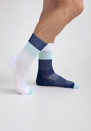 Gestreifte Socken in einer Mischung aus Weiß, Hellblau und Marineblau. Das Design enthält abwechselnd durchgehende und Netzabschnitte.