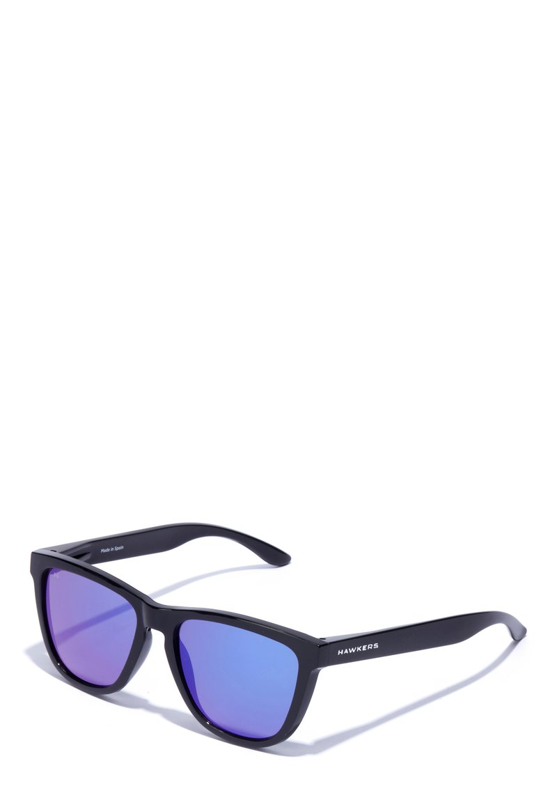 Sunglasses with a matte black frame, purple gradient lenses, angular design, and the brand name "HAWKERS" printed on the temple.