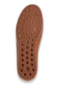 Guma podeszwy buta z teksturowaną powierzchnią z okrągłymi wypustkami, sześciokątnymi wzorami i jasnobrązowym kolorem. Widoczny wyraźny bieżnik.