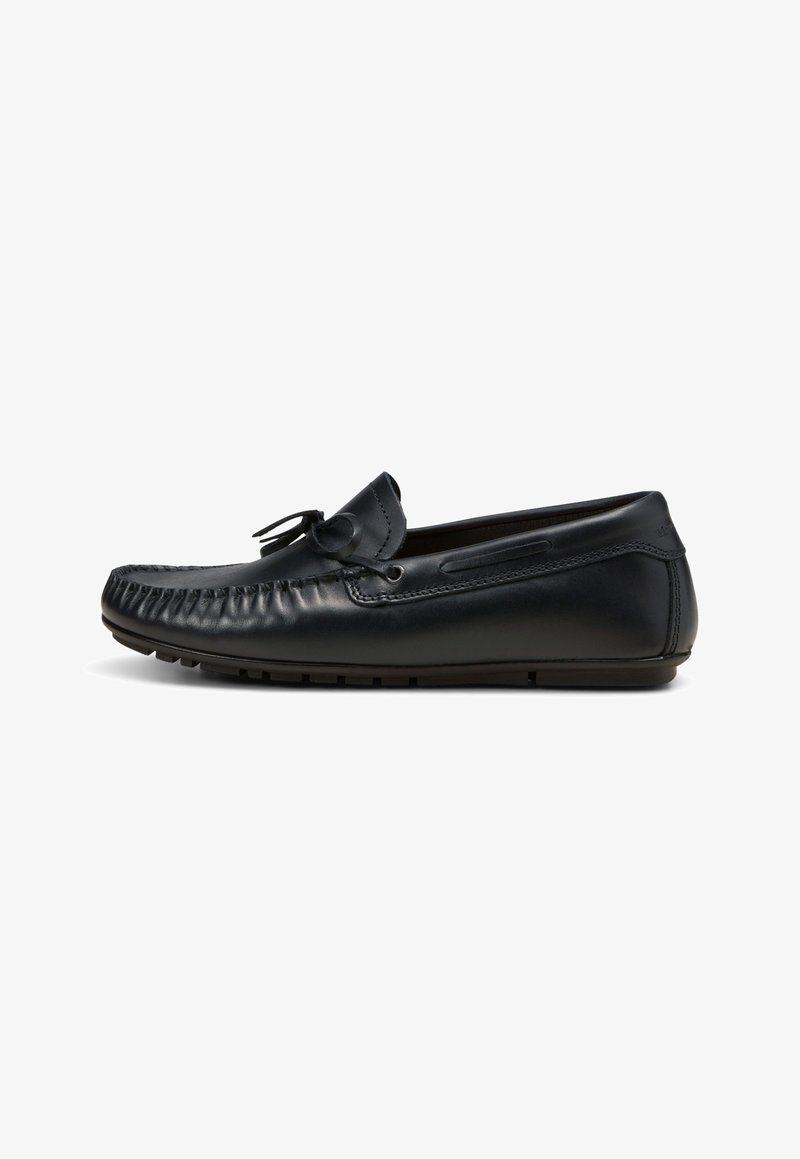 Mocassin pour homme en cuir noir avec couture mocassin et un nœud décoratif sur le dessus, présenté de profil sur fond blanc.