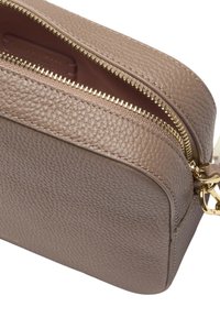 Borsa in pelle marrone con una superficie texture, dotata di una cerniera dorata, forma rettangolare e un accento in metallo dorato.