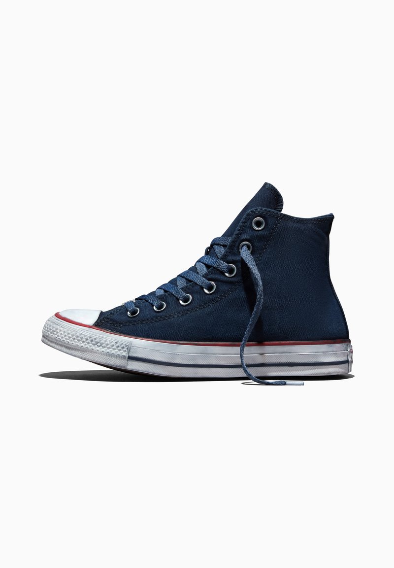 Klassischer marineblauer High-Top-Canvas-Sneaker mit weißer Gummisohle, weißer Zehenkappe und einer losen Schnürung vor weißem Hintergrund.