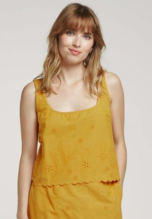 Haut sans manches jaune moutarde avec un décolleté carré, motifs floraux brodés, ourlet festonné et tissu léger.