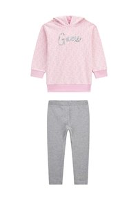 Rózsaszín kapucnis pulóver ismétlődő mintával és fényes betűkkel írt 'Guess', szürke leggings-szel párosítva, melyek alján hímzett 'Guess' felirat található.